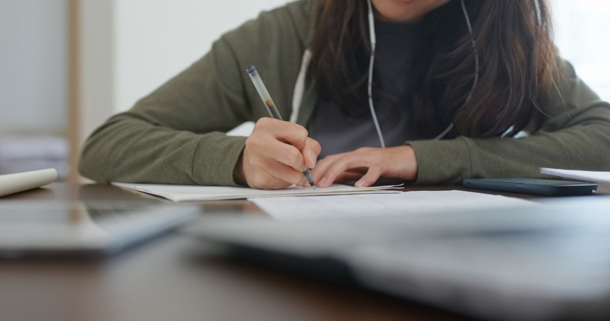 Woman do revision with cellphone at home